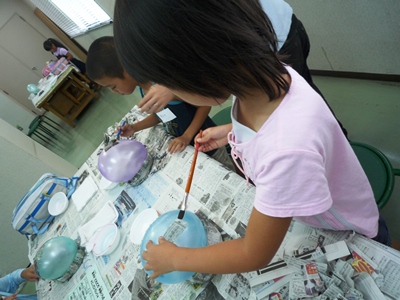 新聞紙を風船に張り付ける作業中