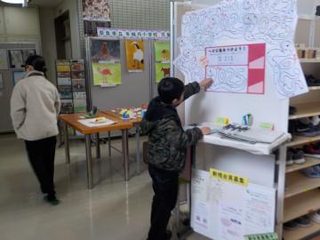 来場者数をカウントするヘビにシールを貼る男の子